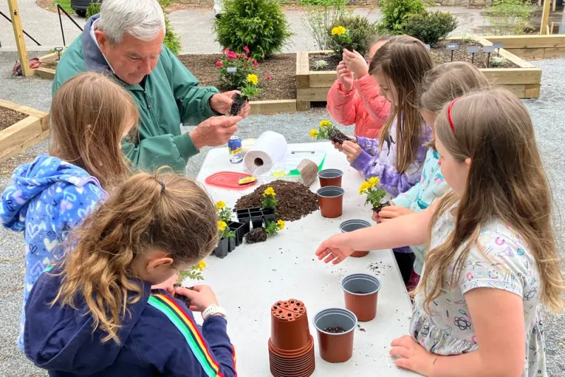Children potting seedlings at a garden workshop